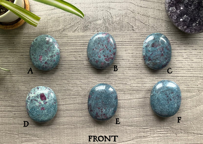 Pictured are various polished ruby in kyanite palm stones.