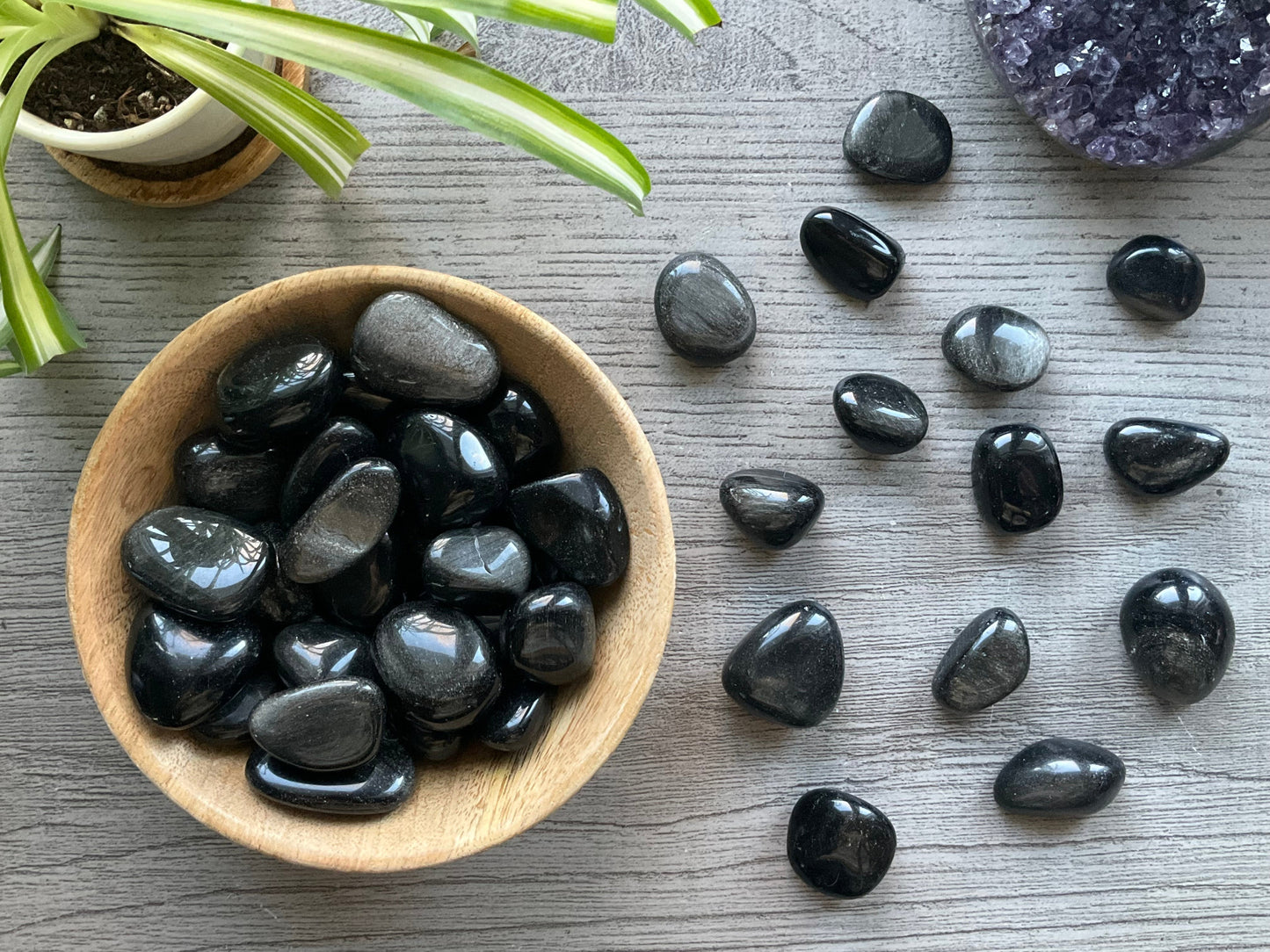 Pictured are various silver sheen obsidian tumbled stones.
