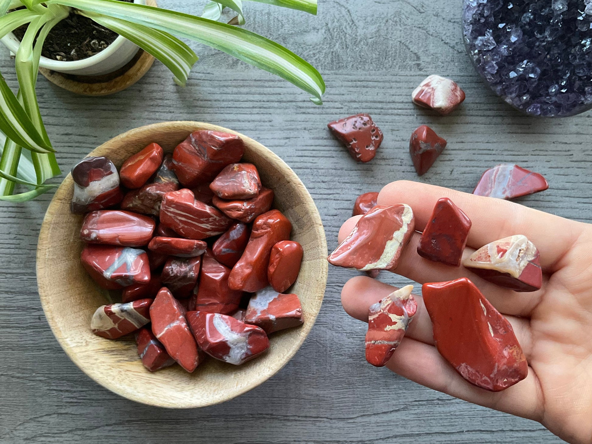 Pictured are various red jasper tumbled stones.