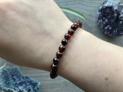 Pictured is a red tiger's eye bead bracelet.