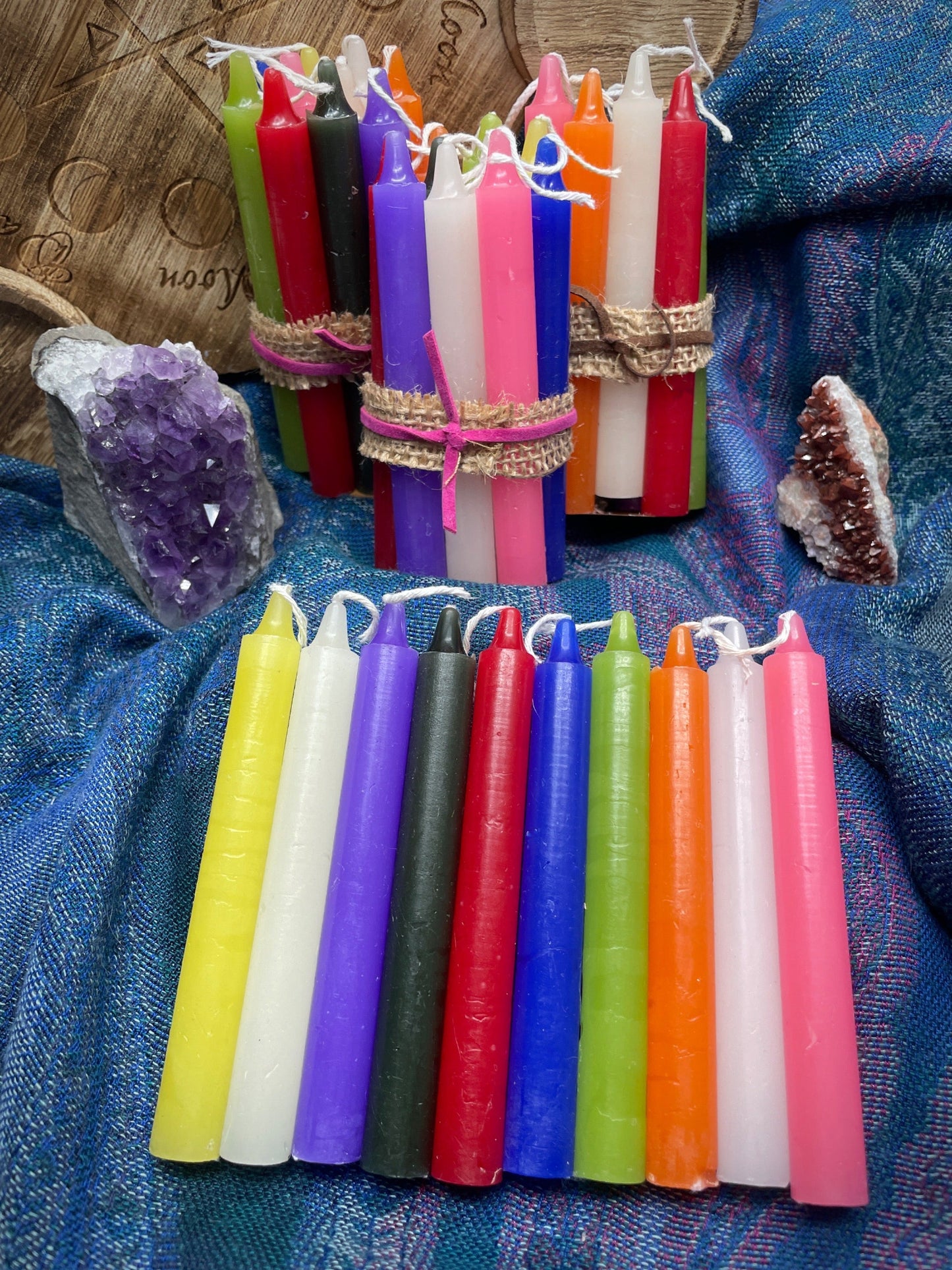 Pictured are various bundles of spell candles or ritual candles.