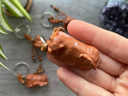 An image of a hand-carved wood tiger on a keychain.
