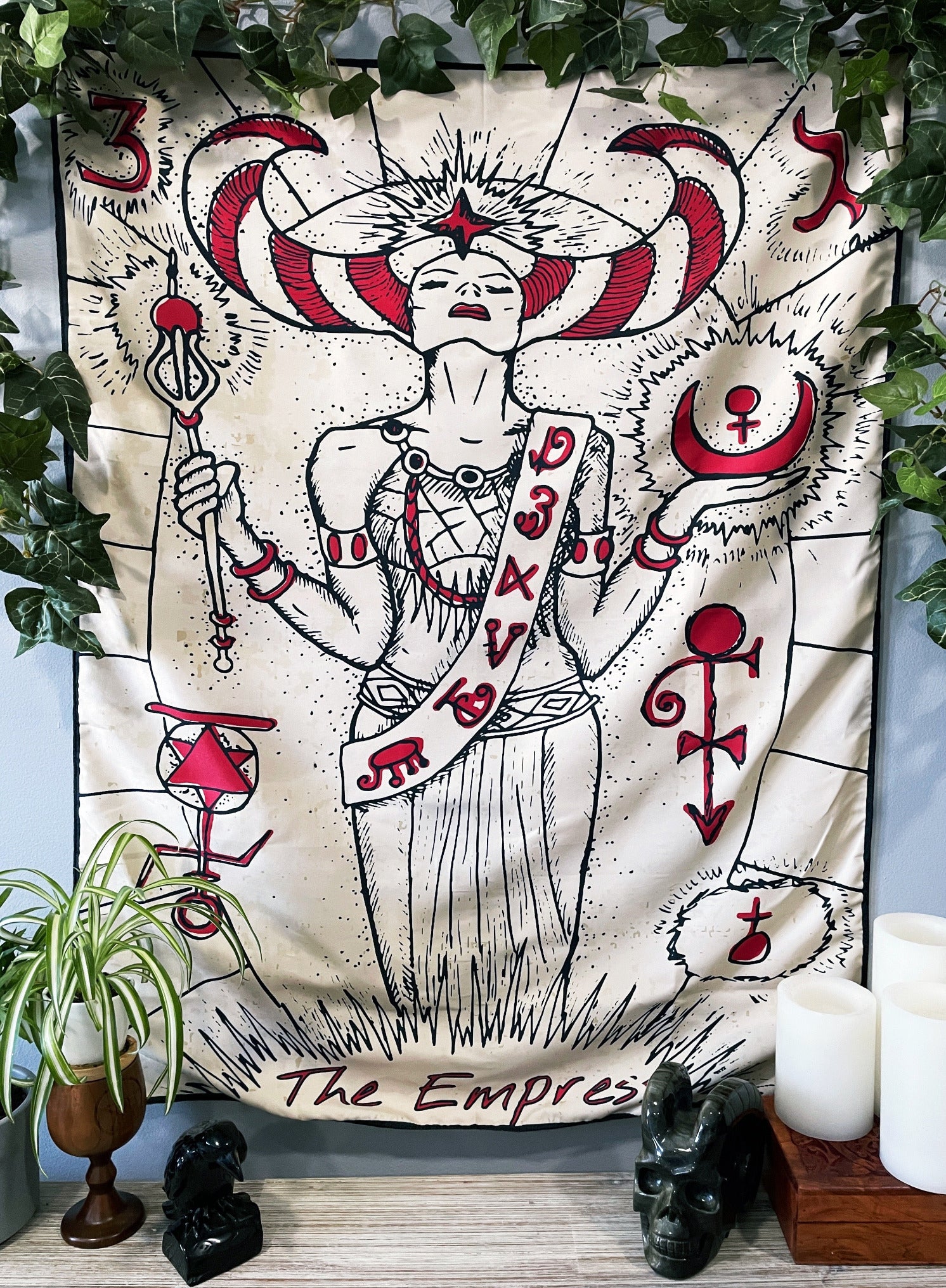 Pictured is a large wall tapestry with a white background and a tarot card of "the empress" printed in black and red on it.