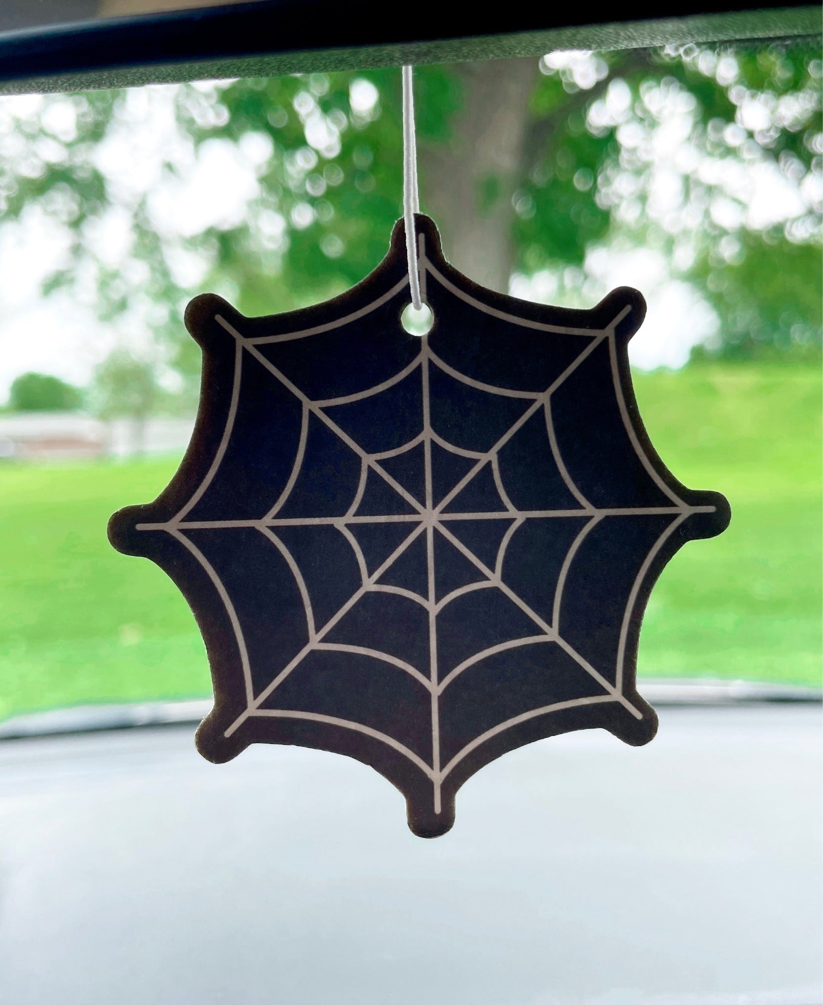 Pictured is an air freshener in the shape of a spider web.