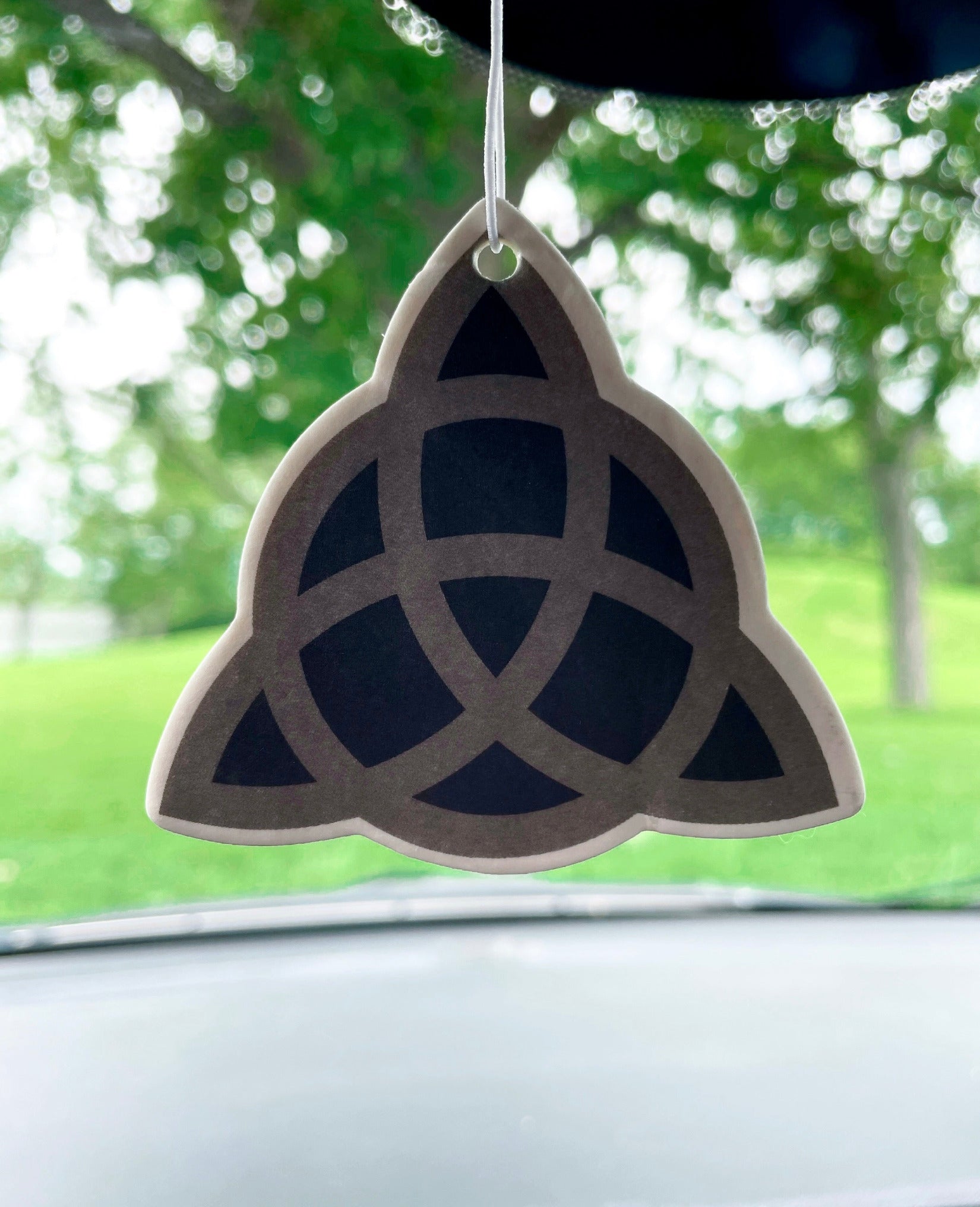 Pictured is an air freshener in the shape of a triquetra