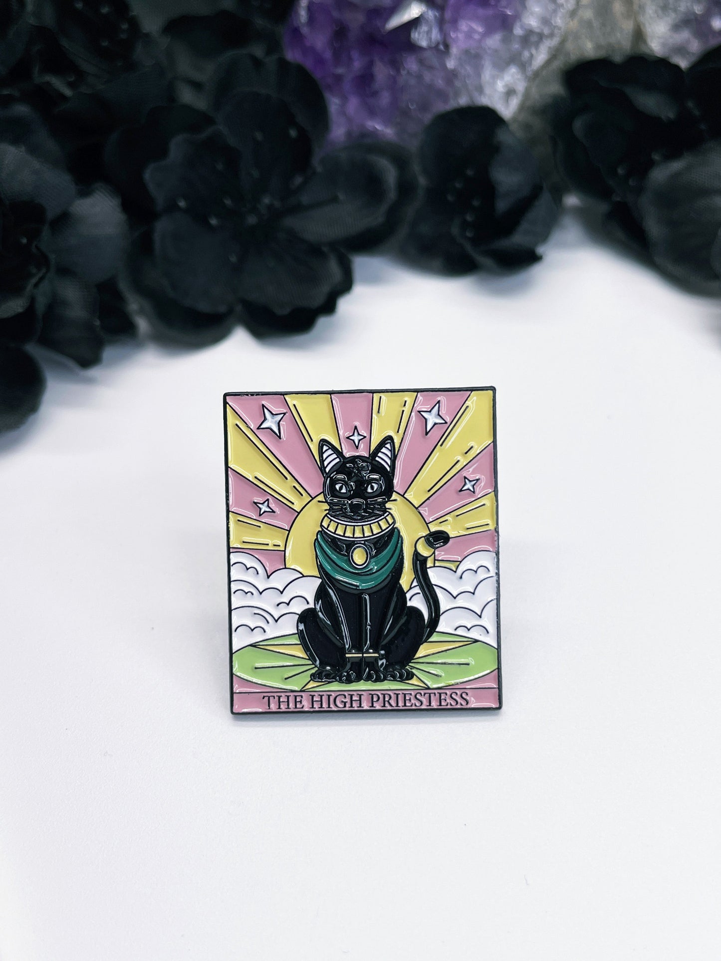  An enamel pin featuring a tarot card with a black cat on it, the card is "The High Priestess."