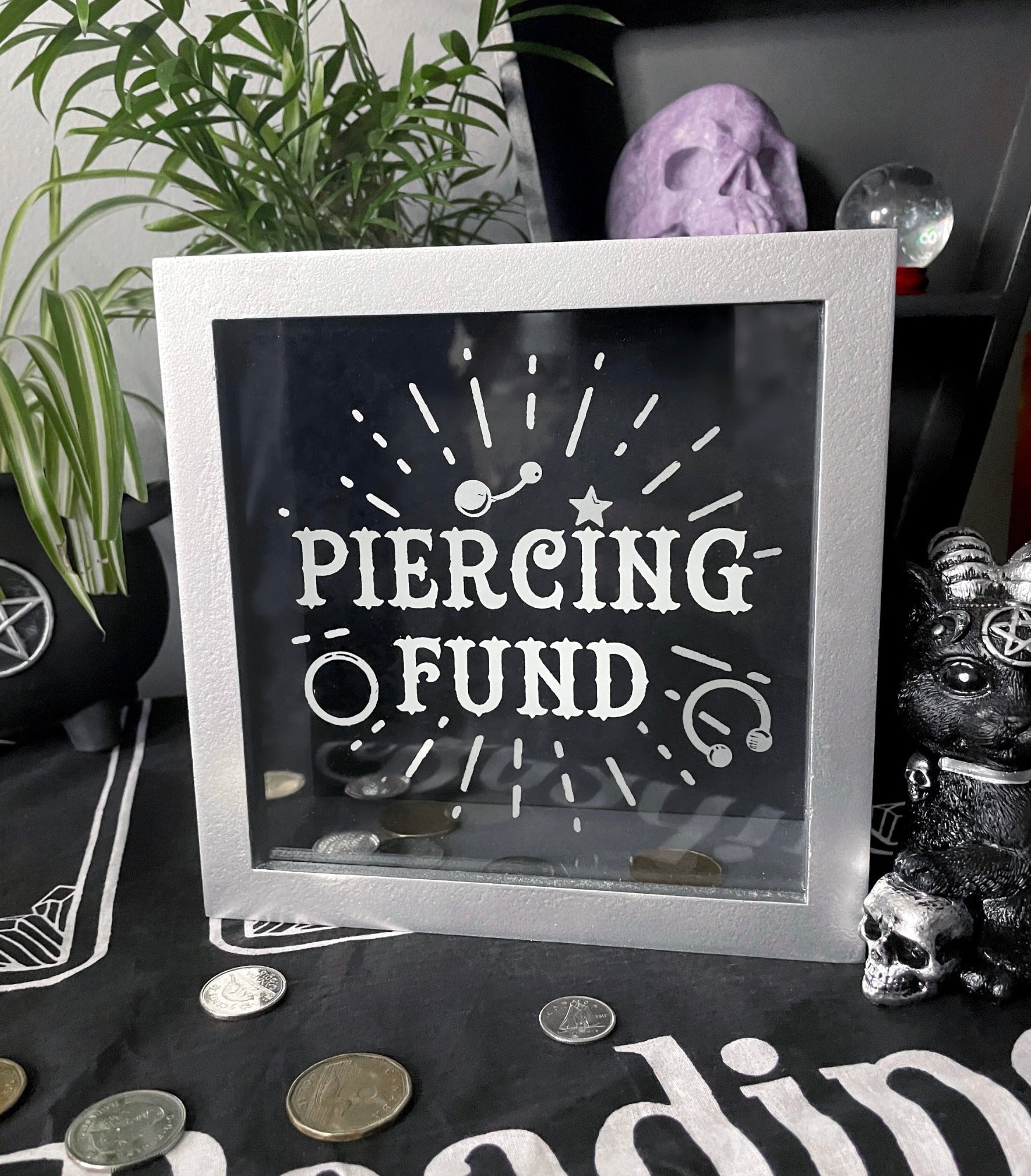 Pictured is a piggy bank or money box with the words "piercing fund" on the front.