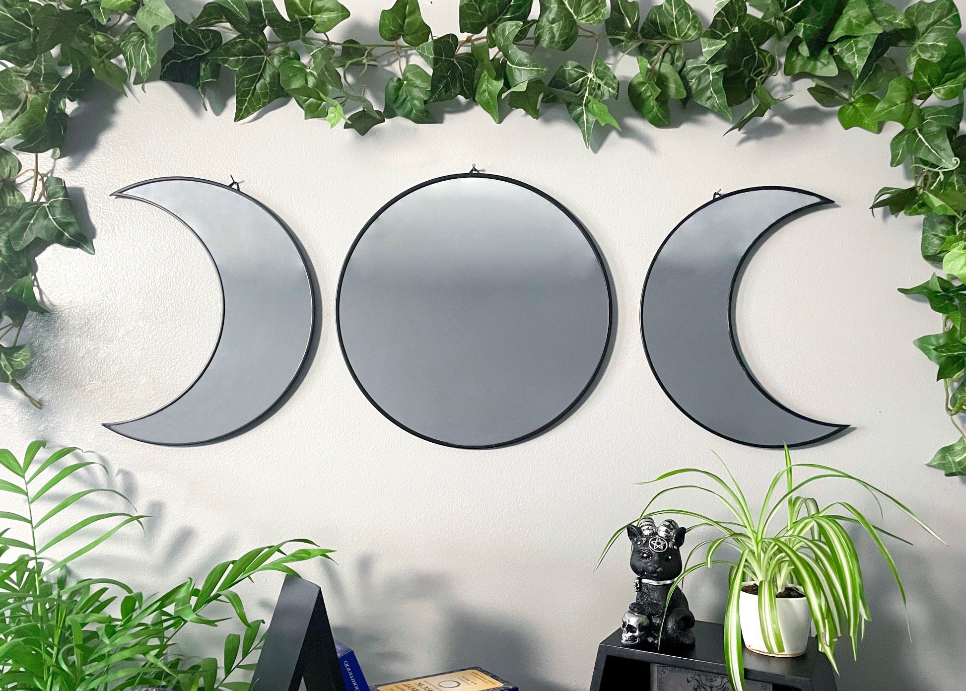 Pictured is a mirror in three pieces shaped like a triple moon three phases of the moon.