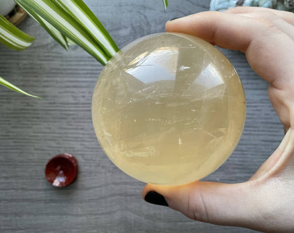 Pictured is a sphere carved out of honey calcite.