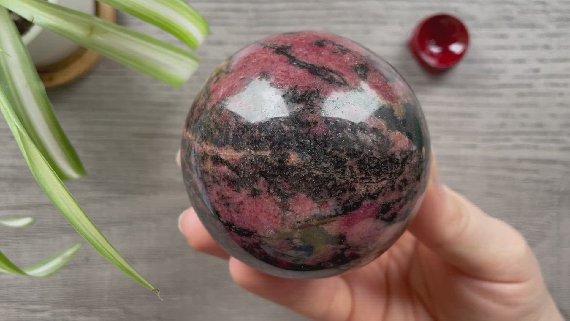 Pictured is a sphere carved out of rhodonite.